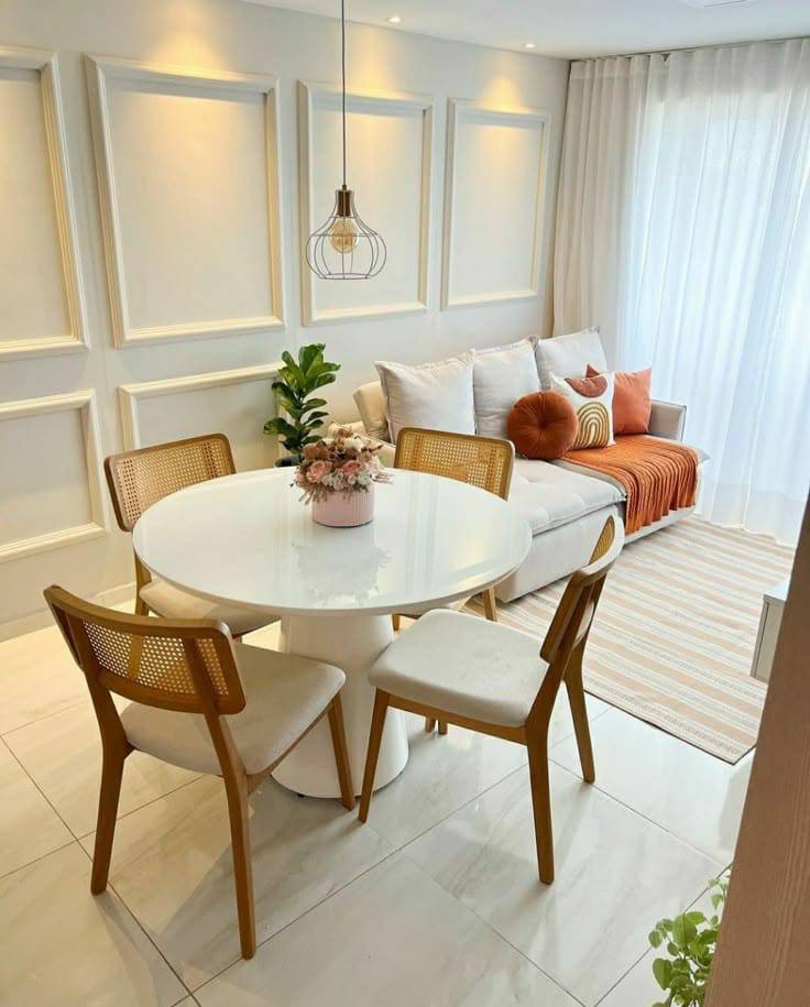 Sala decorada com mesa de jantar redonda, cadeiras e sofá